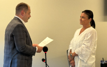 Treasurer administering the oath of office to Ms. Gabrielle Miller