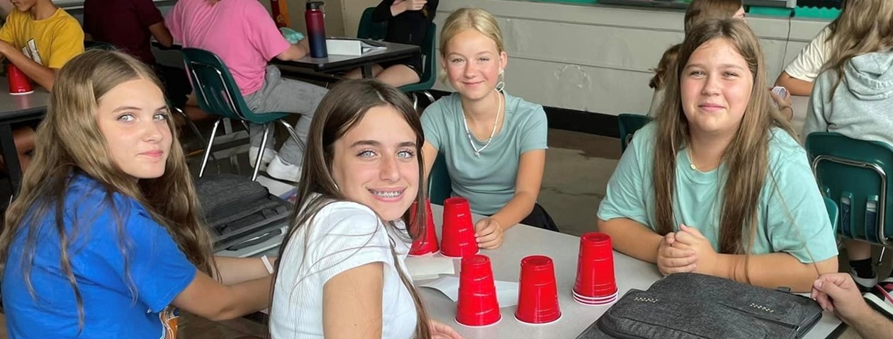 four middle school girls smiling