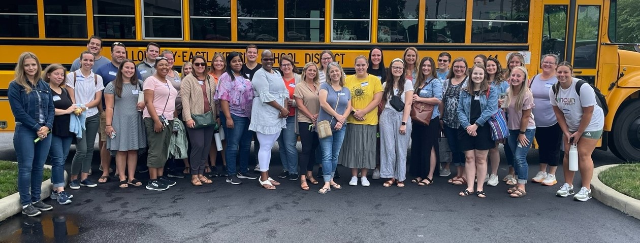 new staff in front of a school bus