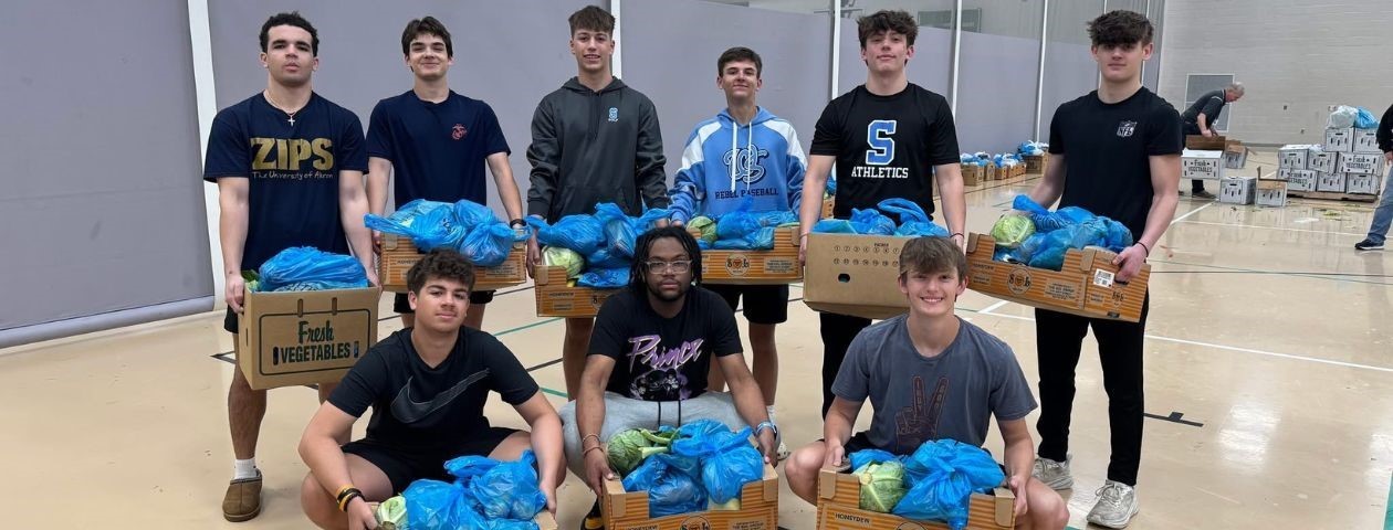Willoughby South High School students with boxes of fresh produce they helped pack and distribute to community residents